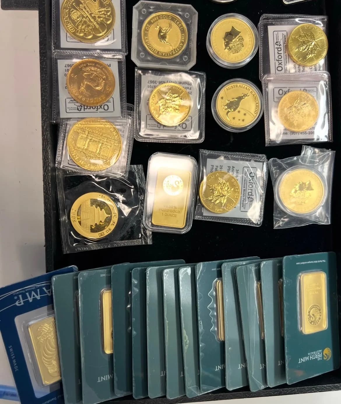 A dealer's tray of gold coins and gold bars in protective holders